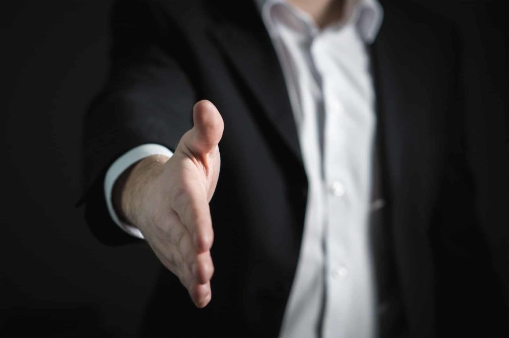 A businessman in black suit shaking his hand