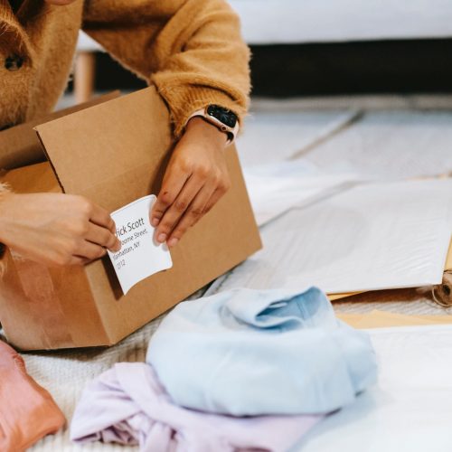 A women is sticking the notes on packaging box