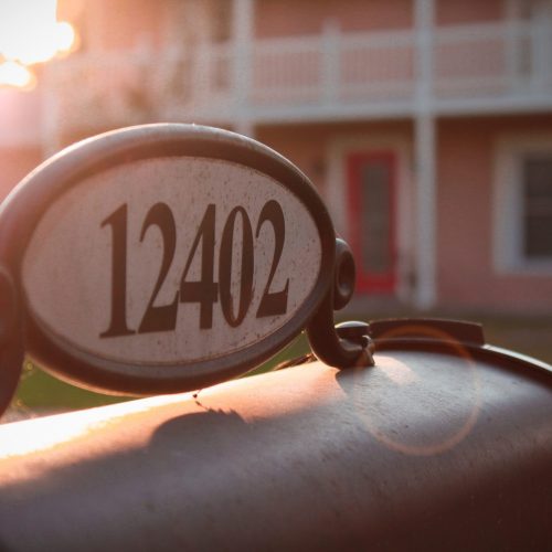 a mailbox with a number on it in front of a house.